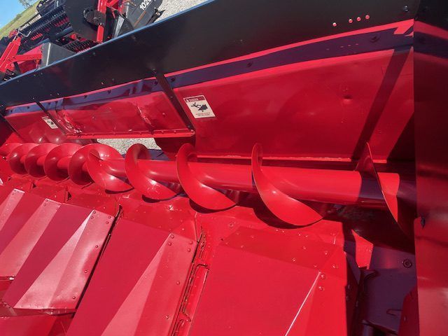 Close-up of red combine harvester auger and conveyor machinery