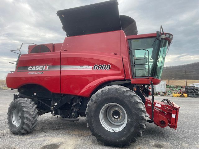 Red Case IH 7088 combine harvester parked on a gravel lot under a cloudy sky