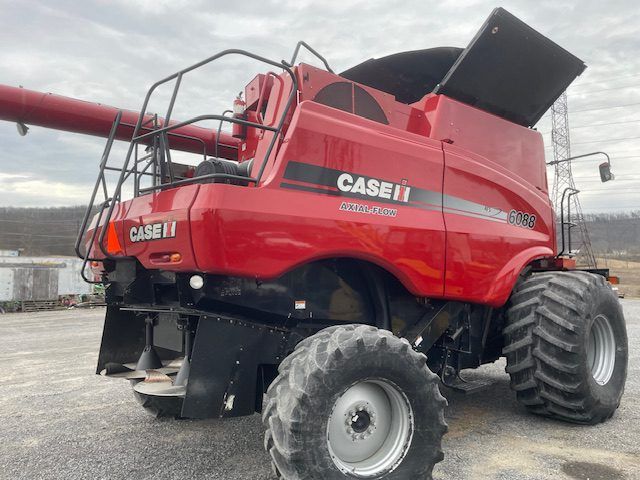 Red Case IH combine harvester with extended auger parked on snowy ground