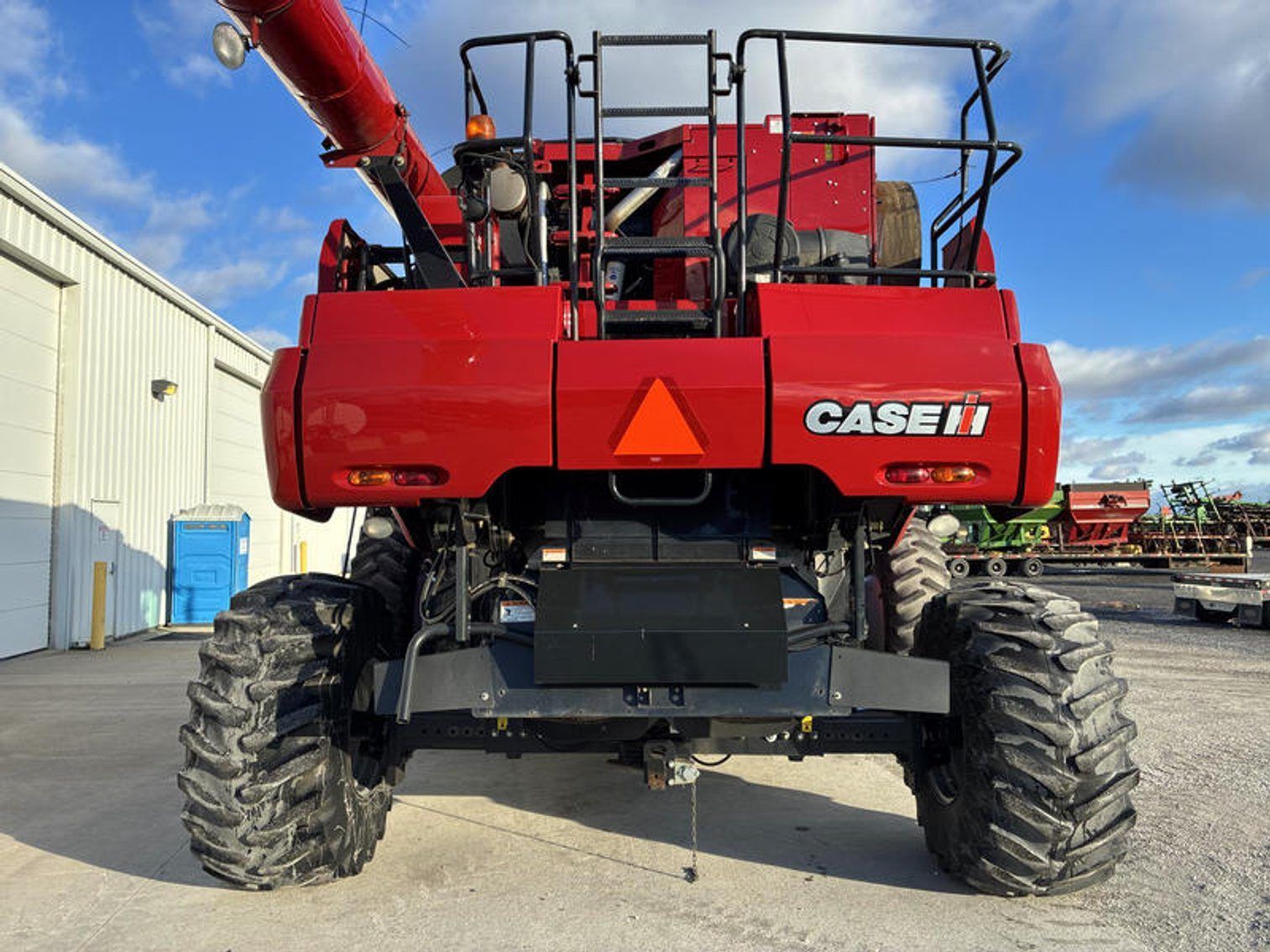 Red CASE IH agricultural combine harvester viewed from the front in an outdoor yard.