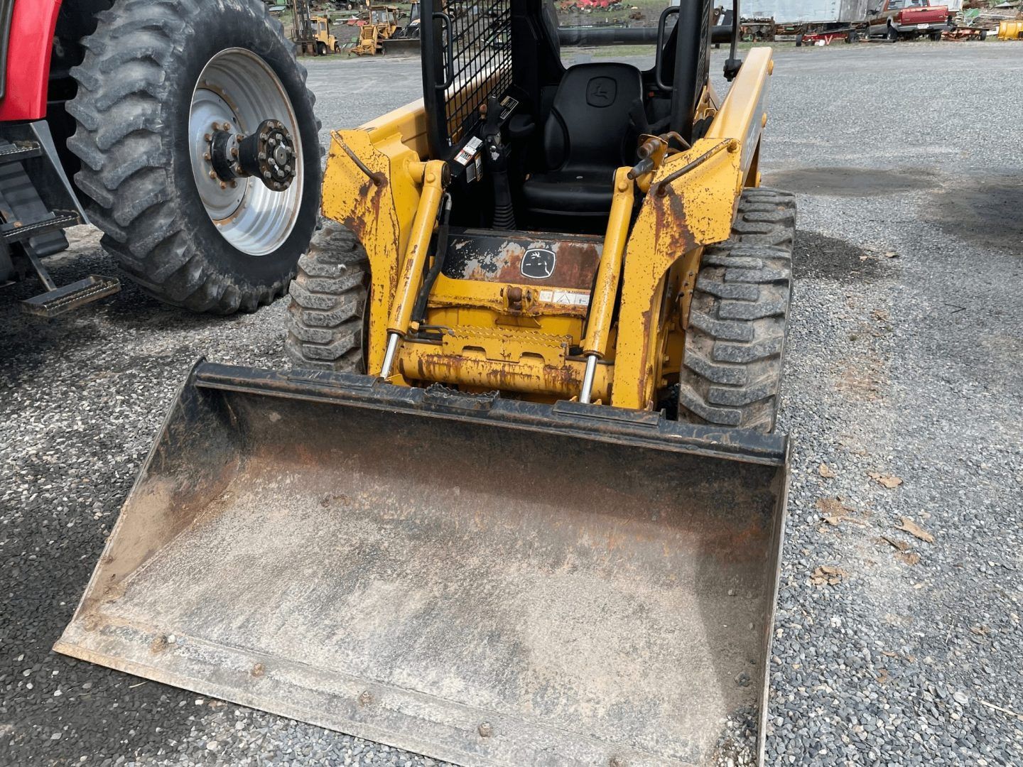 Yellow front-end loader with bucket on gravel at a construction site