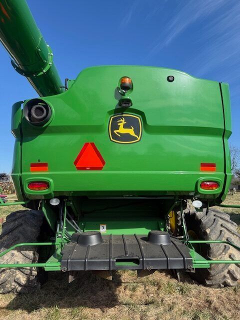 Rear view of a green John Deere combine harvester in a field