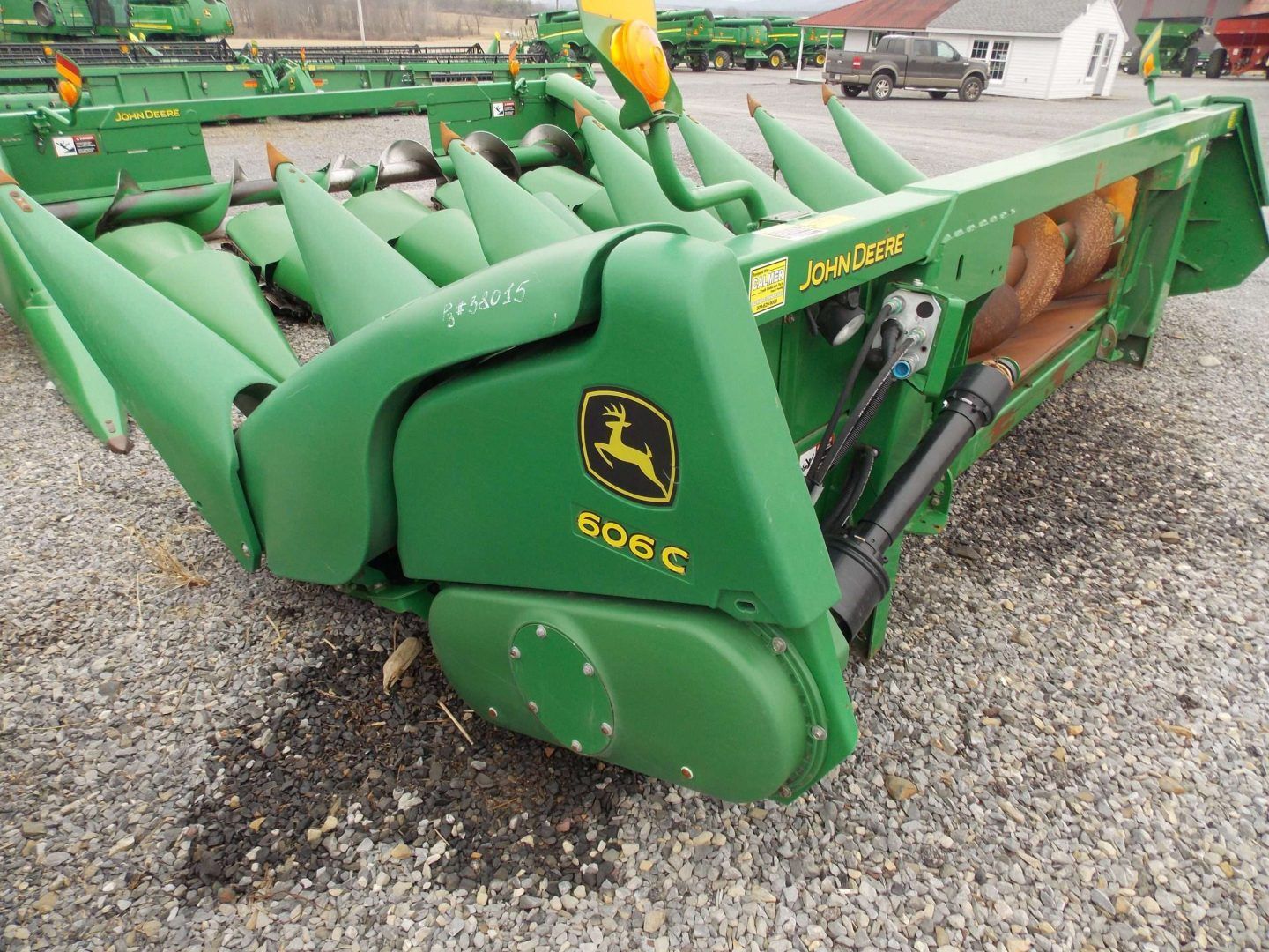 Green John Deere 50C skid steer attachment parked on gravel lot