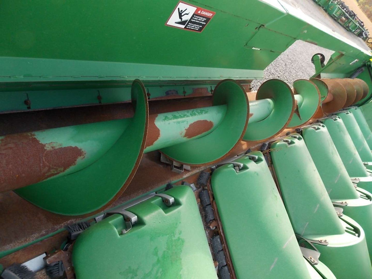 Green industrial machinery with large helical augers inside a metal housing