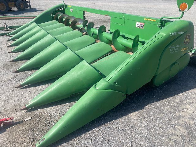 Green agricultural header with pointed cones on display outdoors