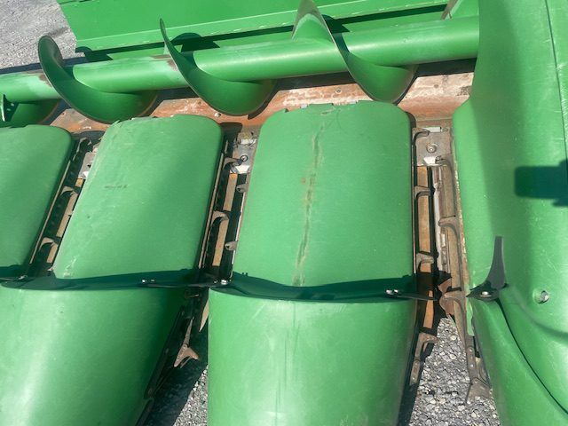 Green stadium seats folded down in rows, viewed from above.