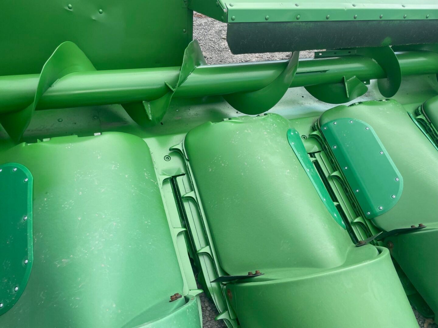 Green plastic stadium seats with metal railings, viewed from above.
