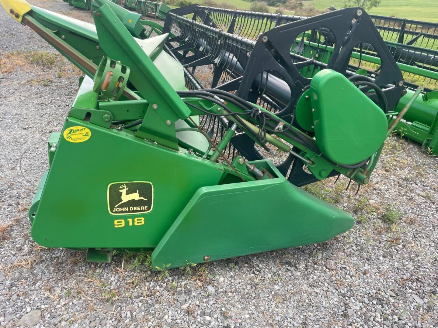 Green John Deere S18 mower attachment on gravel, shown in side view