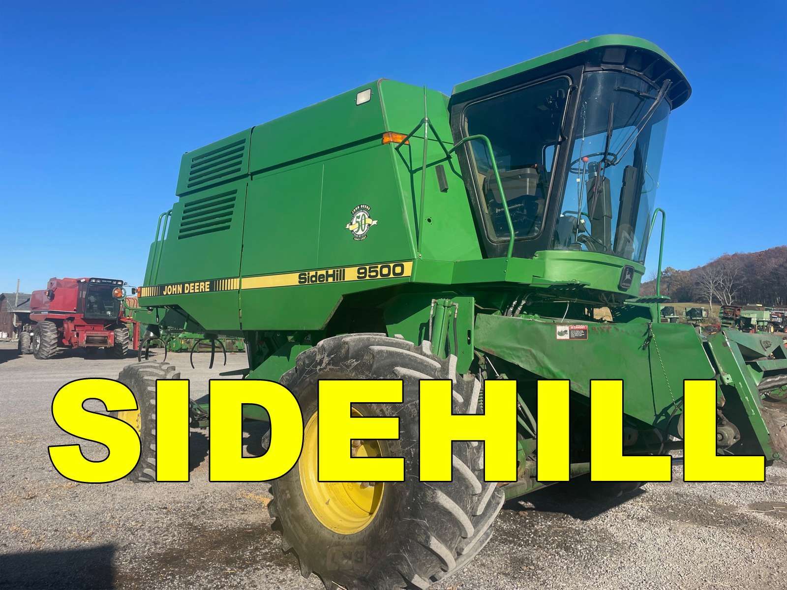 Green sidehill combine harvester on gravel lot under blue sky, with “SIDEHILL” text overlay.