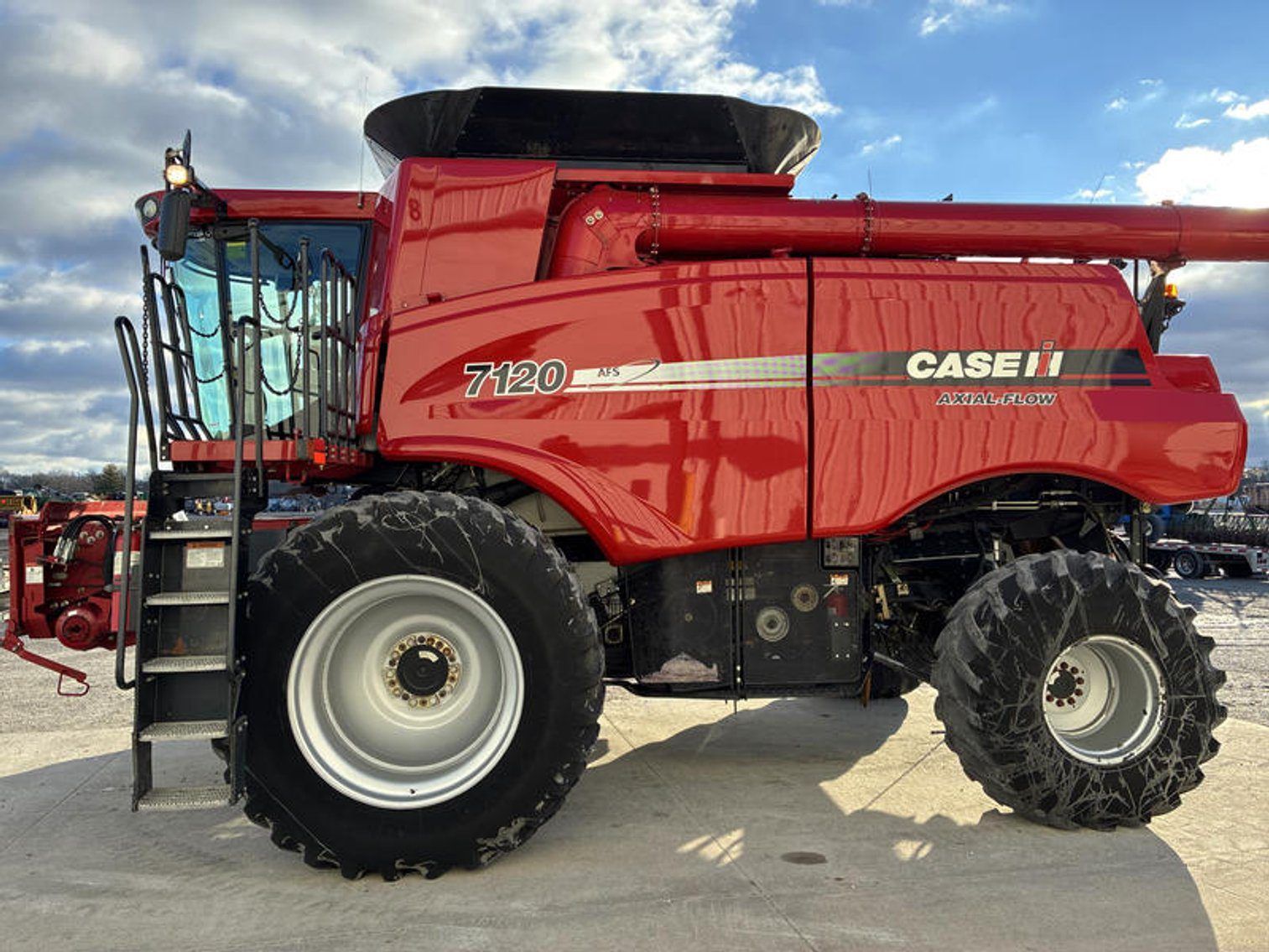 Red Case IH combine harvester parked outdoors under a cloudy sky