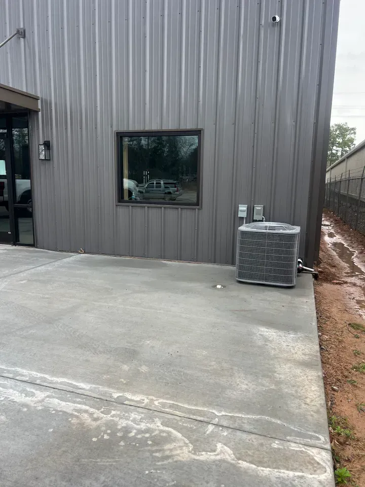 A building with a window and an air conditioner on the side of it.