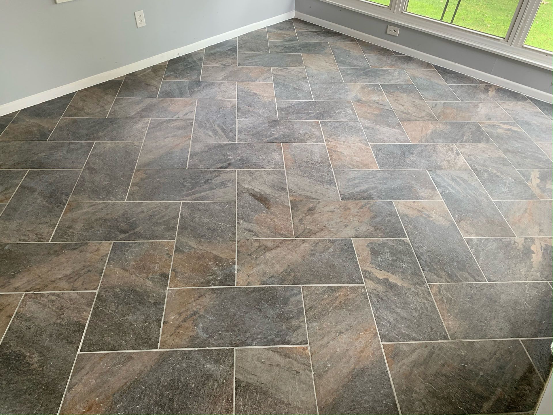 A room with a tiled floor and a window.