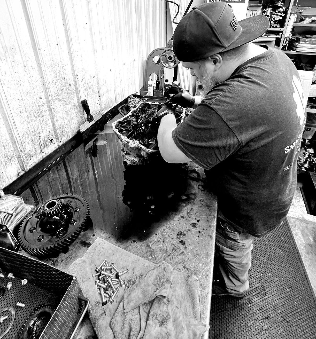 A man is working on a machine in a black and white photo.