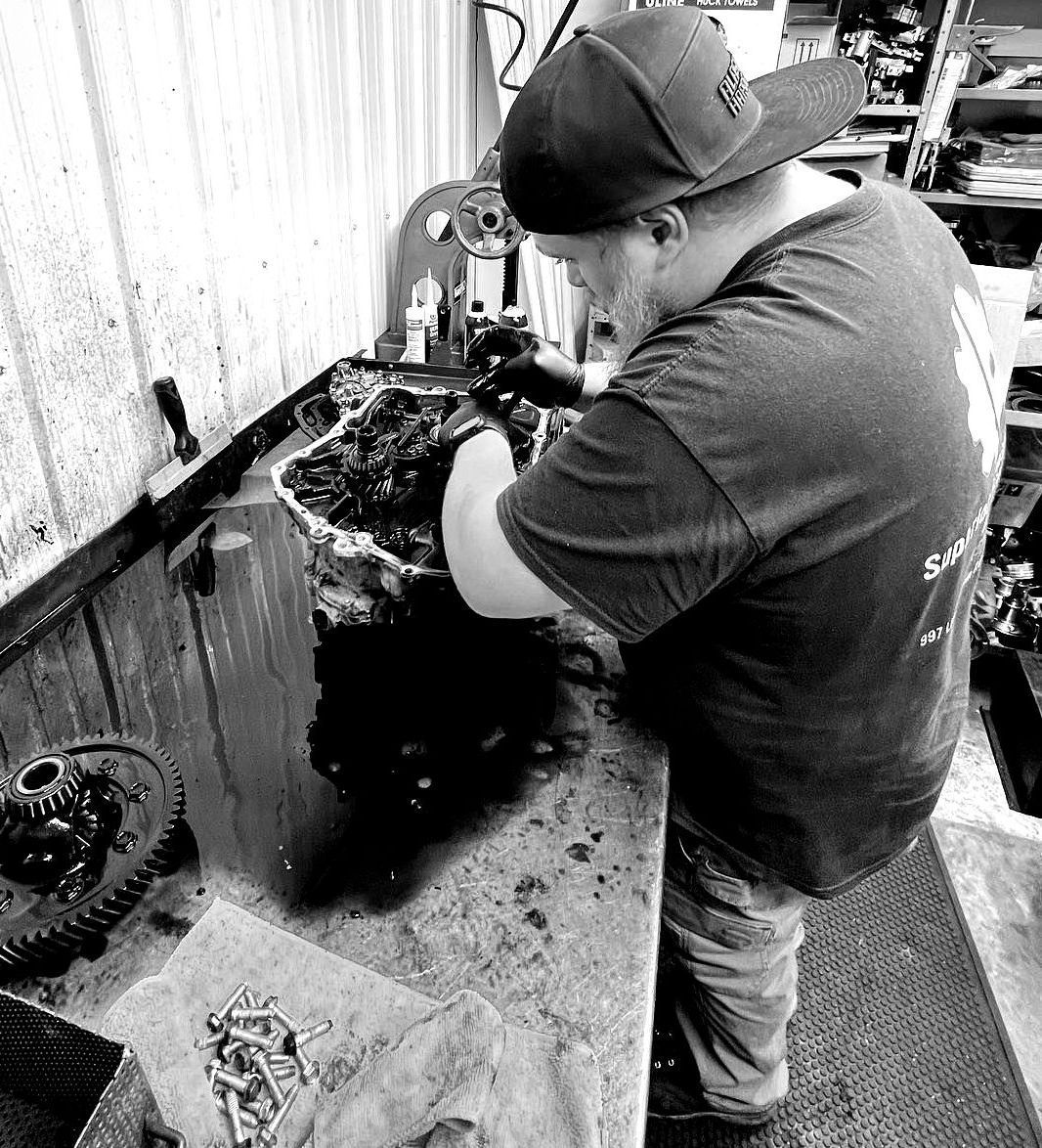 A man is working on a machine in a black and white photo.