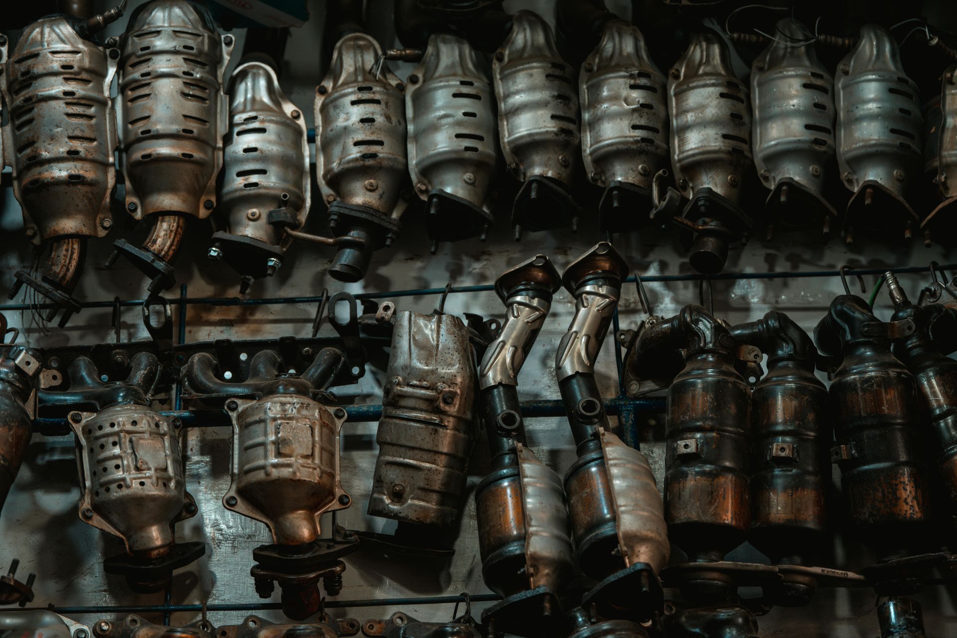 There are many different types of catalytic converters hanging on the wall.