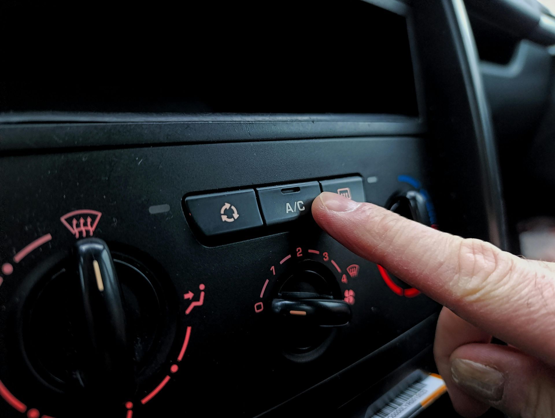 A person is adjusting the air conditioning in a car.
