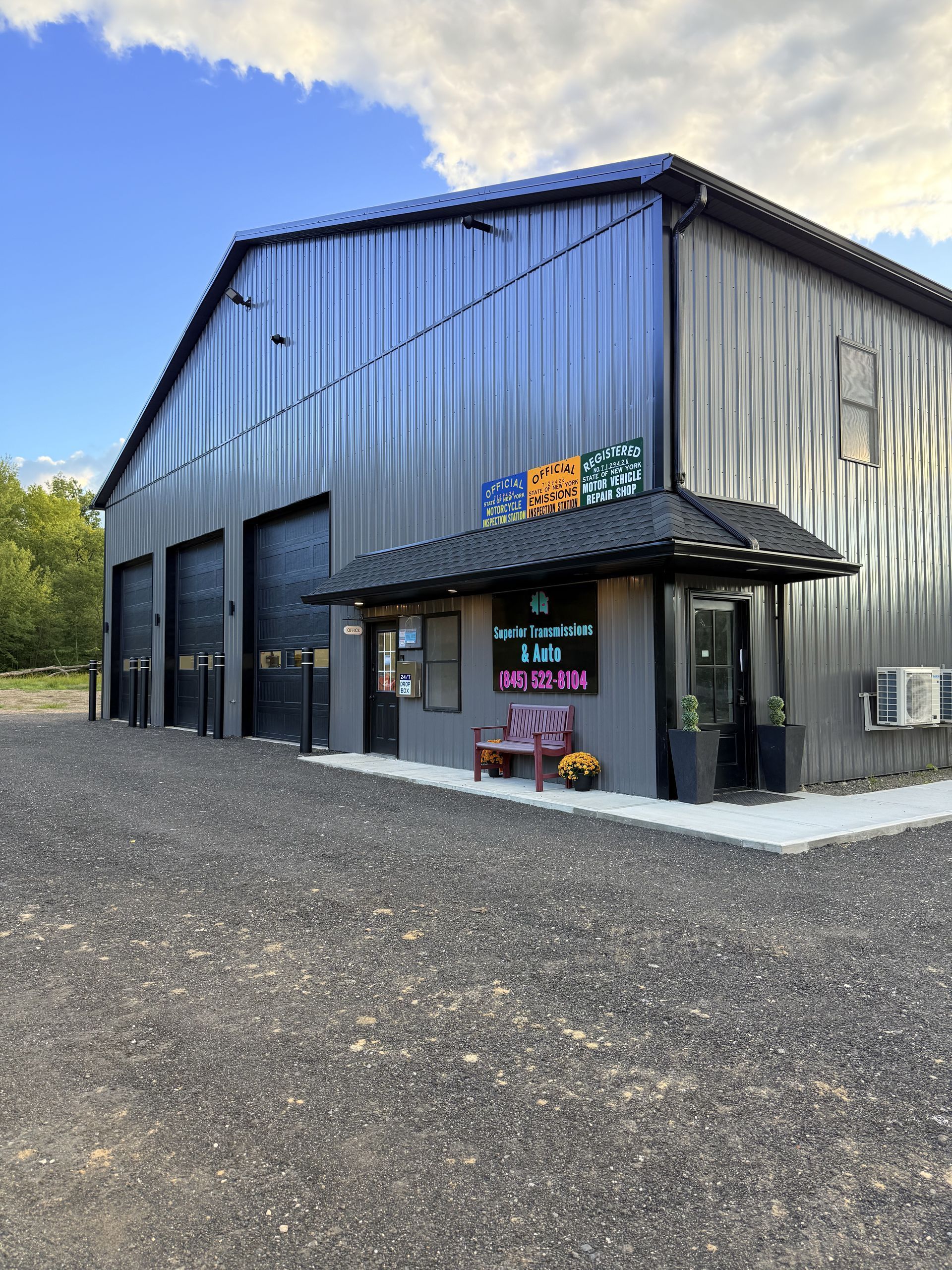Gray metal building with black garage doors and a small entrance. A sign reads “Soul Sanctuary Farm”.