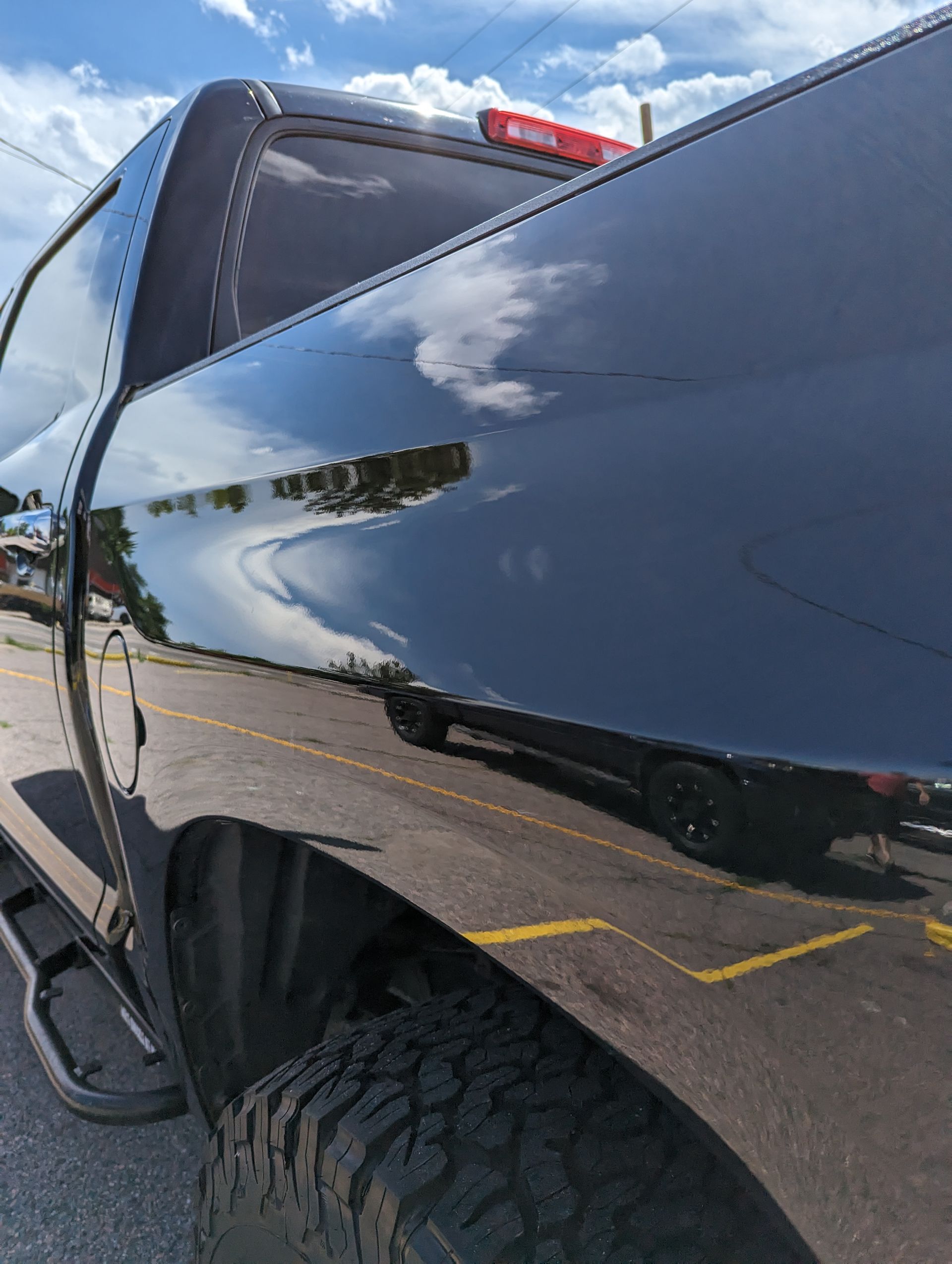 A black truck is parked in a parking lot.