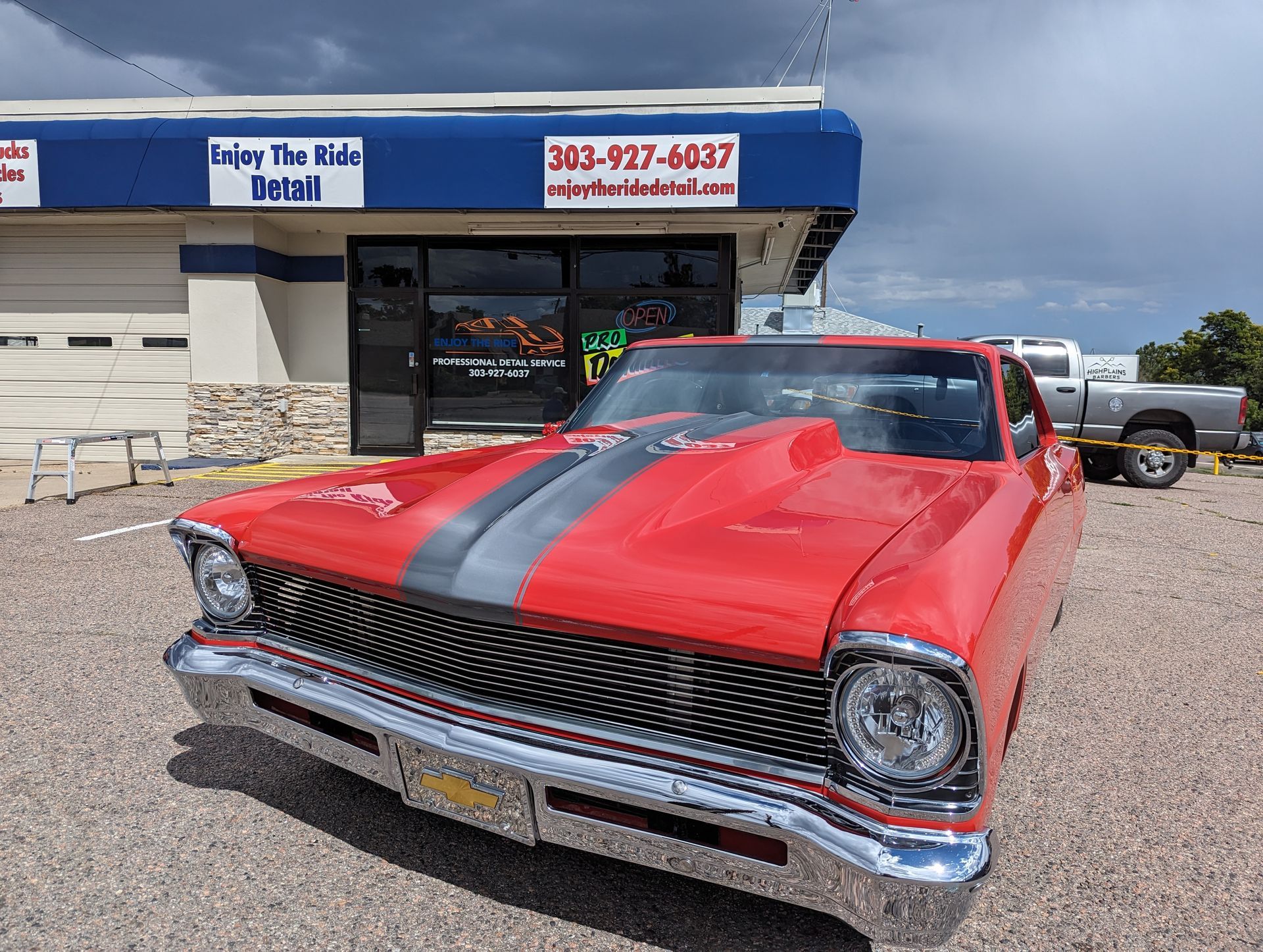 A red car is parked in front of a building.