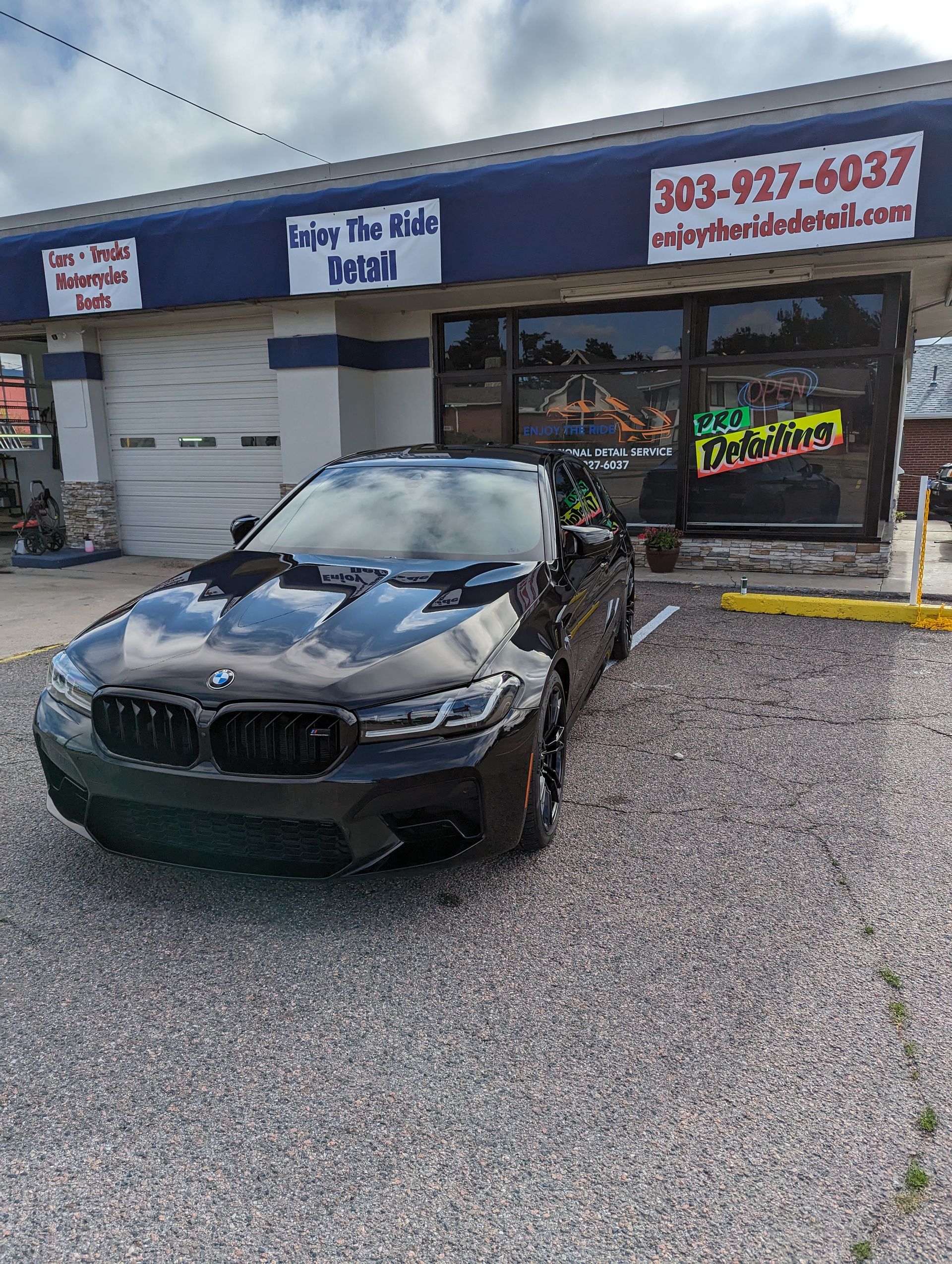 A black car is parked in front of a building.