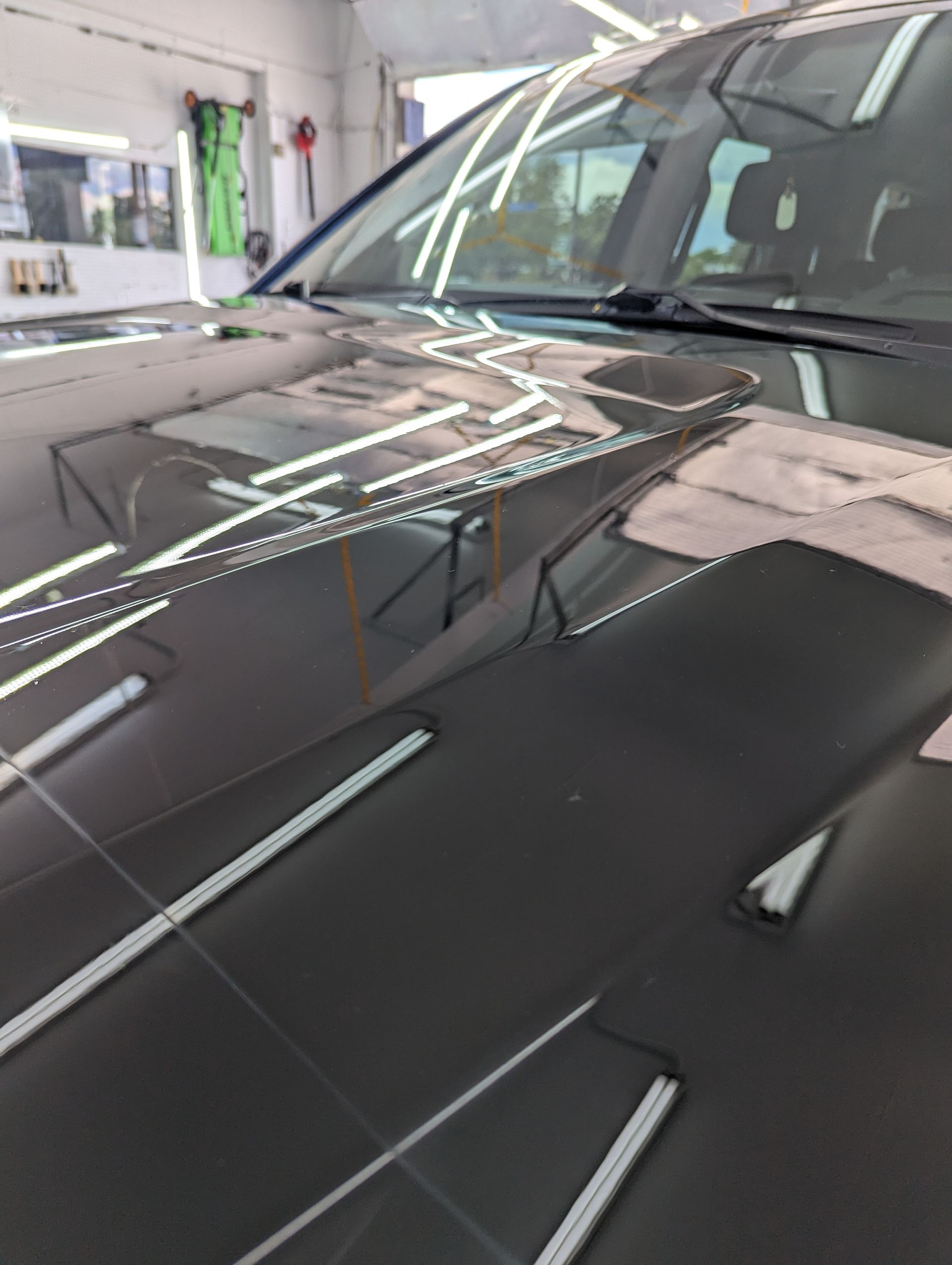 A close up of the hood of a car in a garage