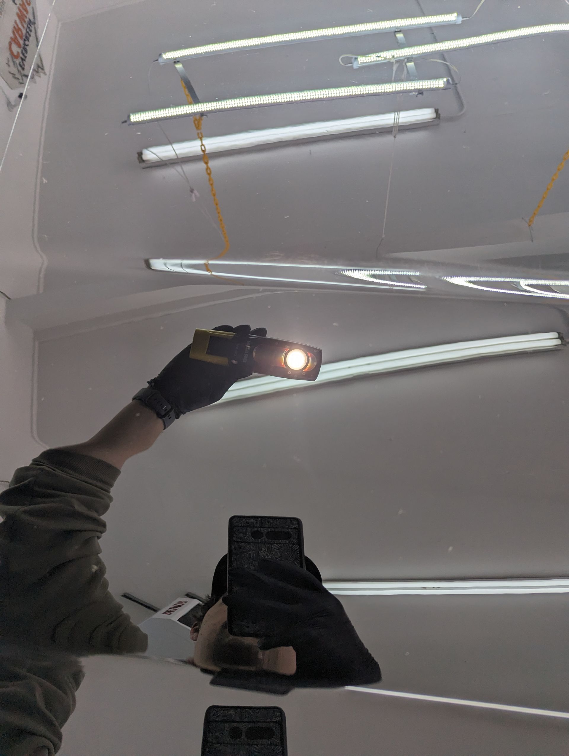 A person is holding a flashlight in front of a mirror.