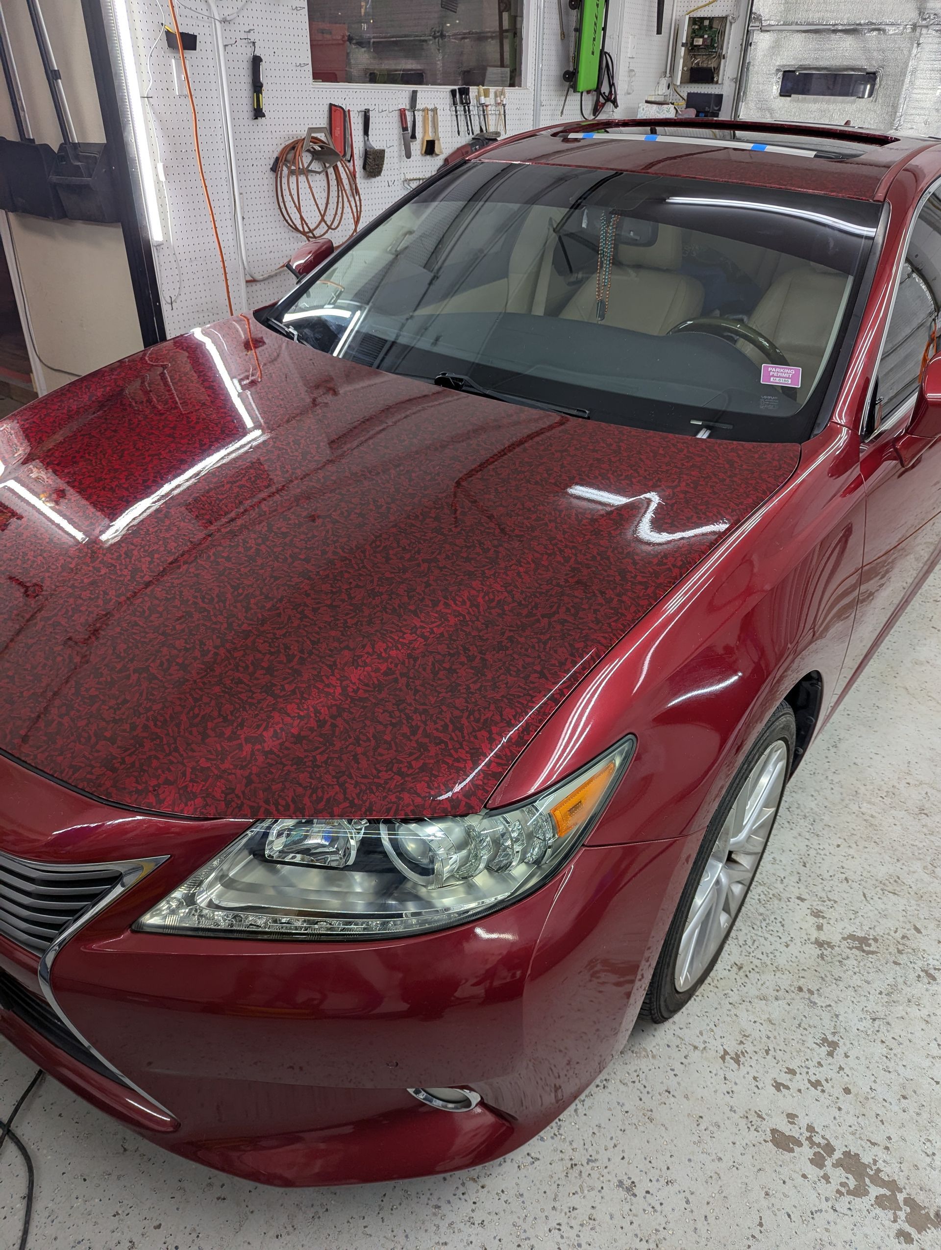 A red car is parked in a garage.