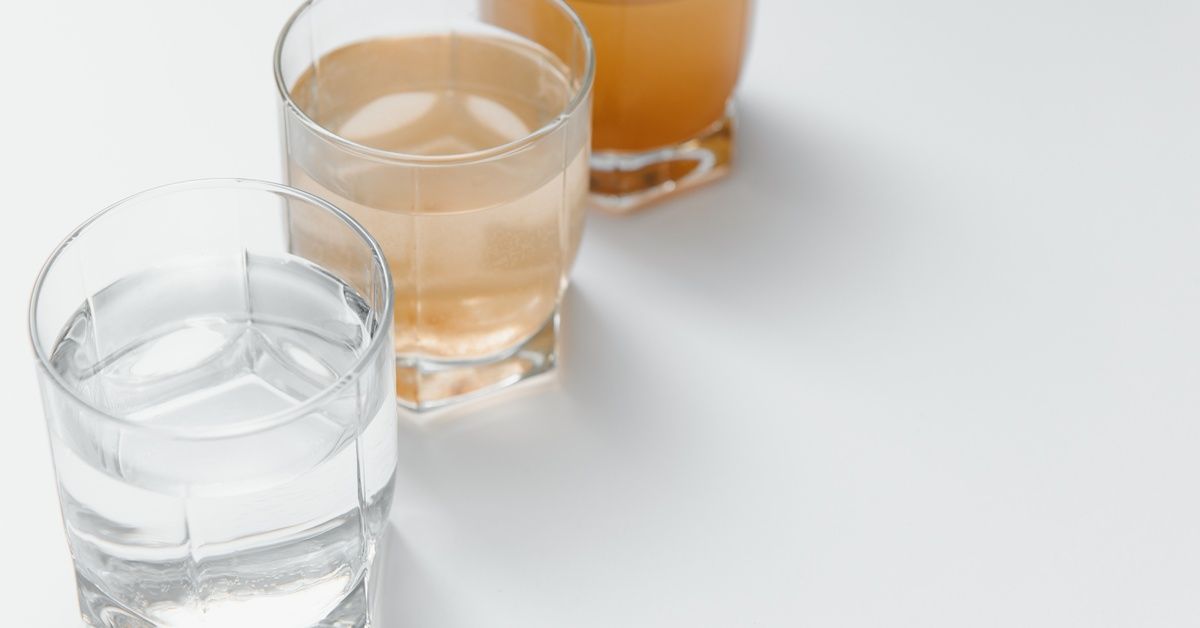 Three glasses of water. The first is clear, the second is slightly cloudy, and the third is brown.