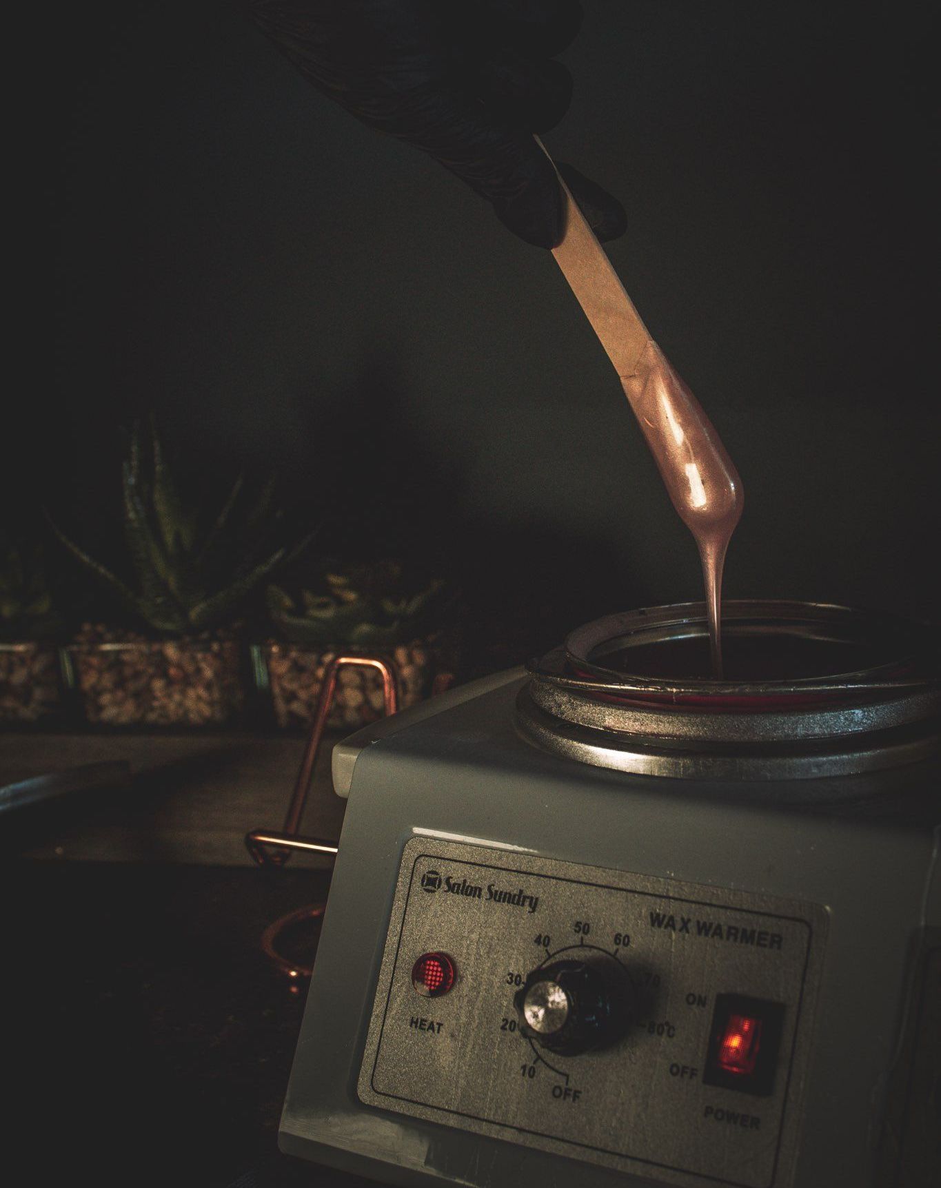 A person is pouring wax into a wax warmer.