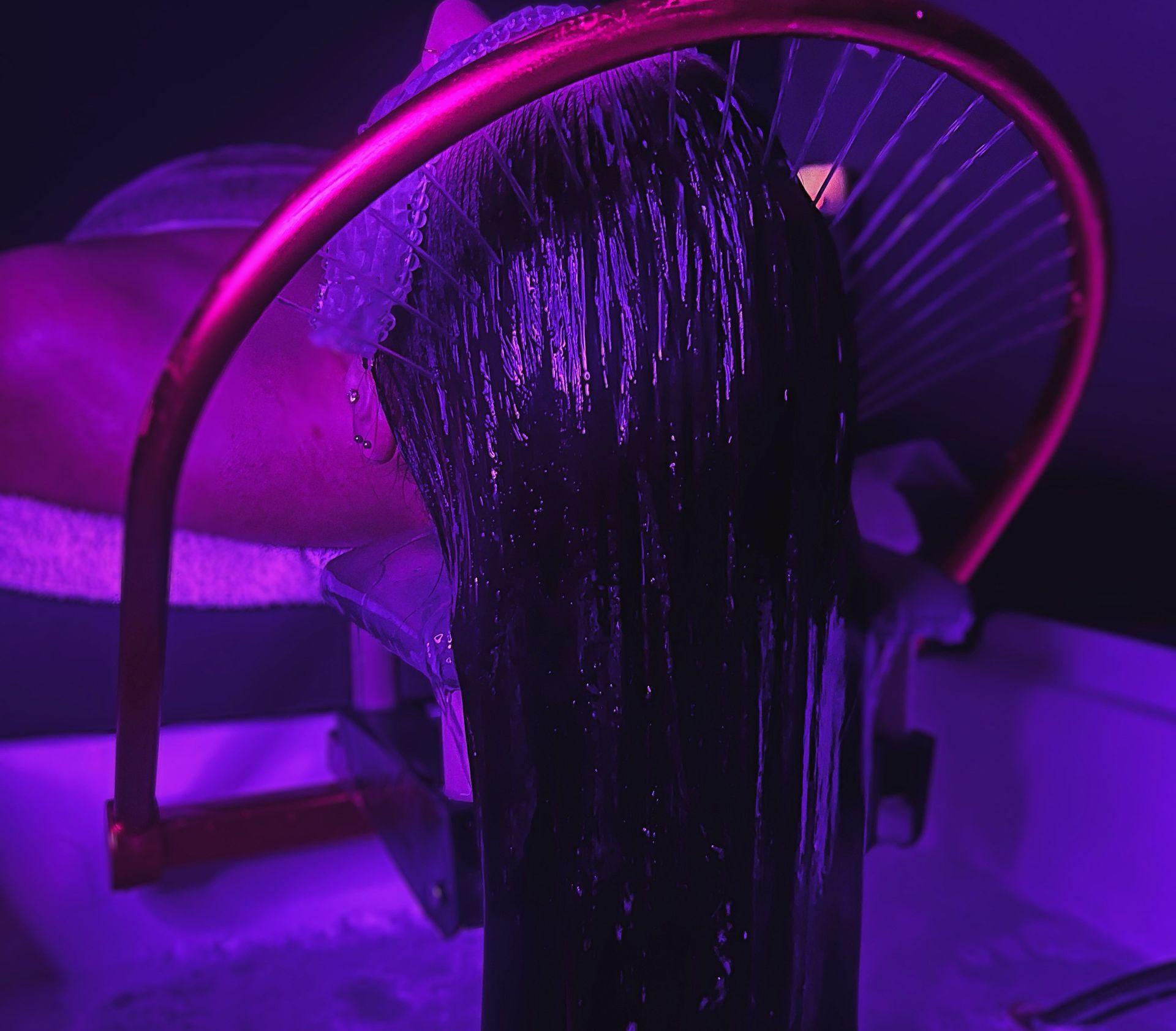 A purple light is shining on a bottle of wine.