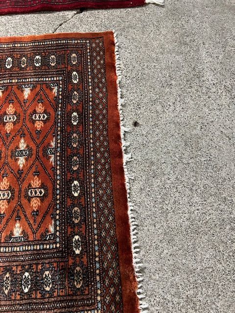 A rug is sitting on top of a carpet on the floor.