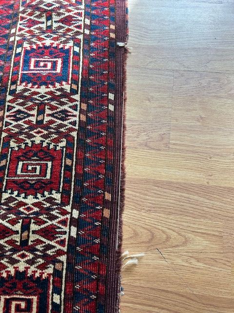 A close up of a rug on a wooden floor