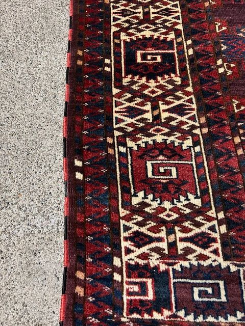 A close up of a rug with the letter g on it