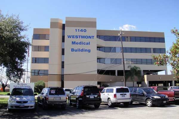 A man in a blue shirt is getting his back examined by a doctor.