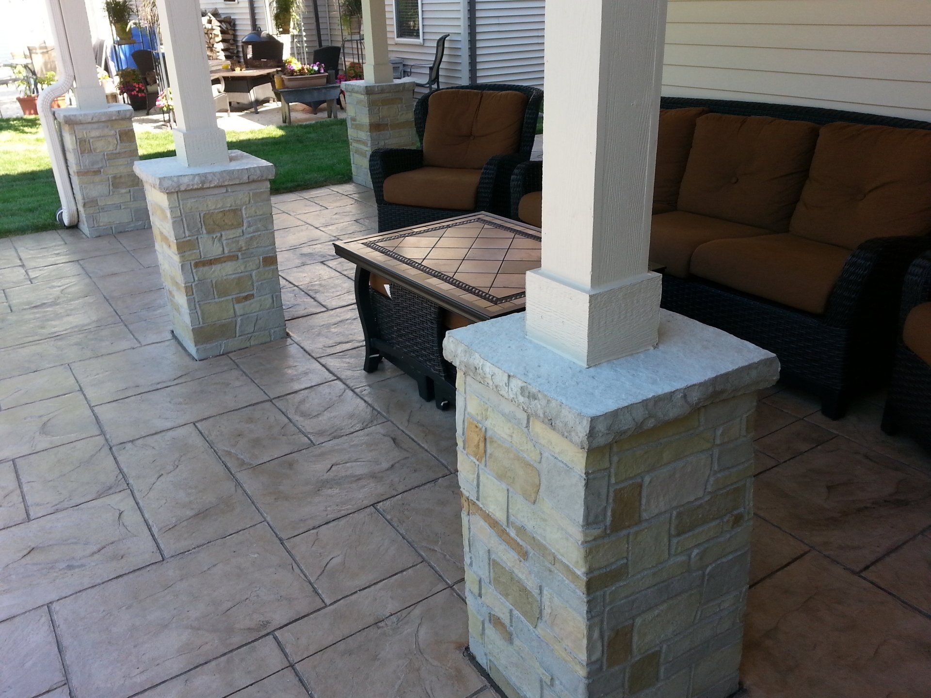 a patio with a couch and chairs and a table