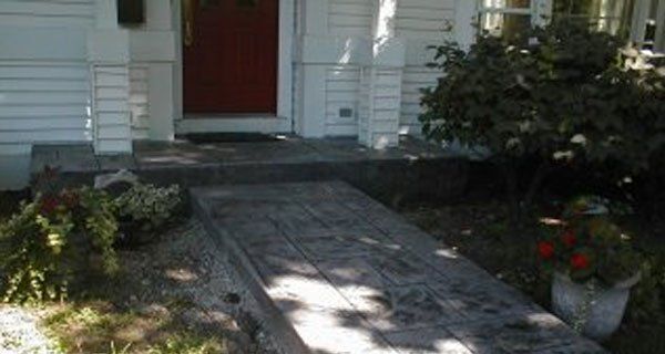 a concrete walkway leading to the front door of a house .