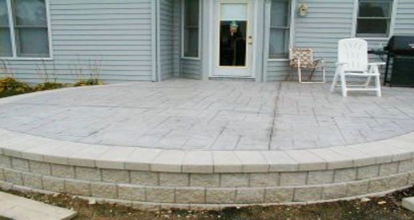 a patio with a chair and a grill in front of a house .