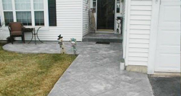a white house with a concrete walkway leading to the front door .