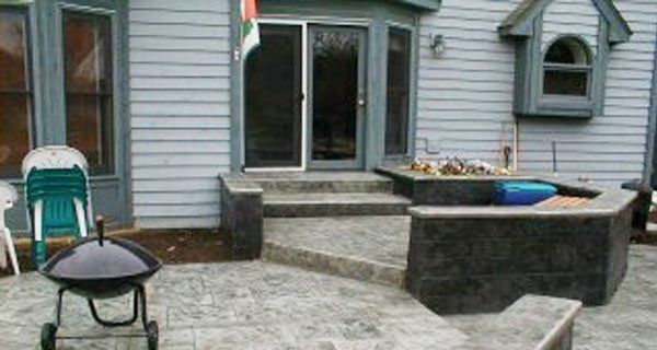 a grill is sitting on a patio in front of a house .