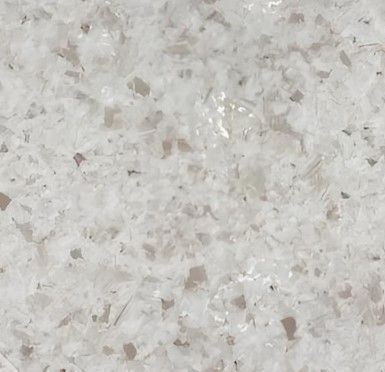 A close up of a white tile with a lot of small stones on it.