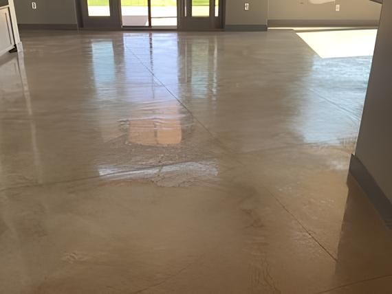 A shiny concrete floor in a living room with a sliding glass door.