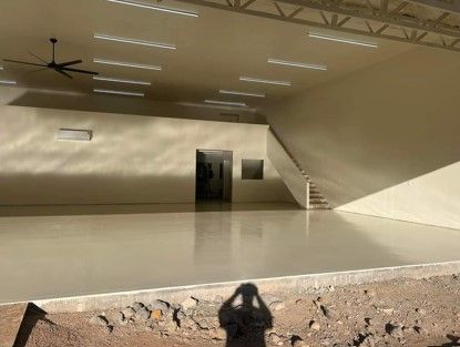 An empty room with a ceiling fan and stairs