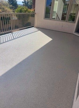 There is a balcony with a railing and a concrete floor.