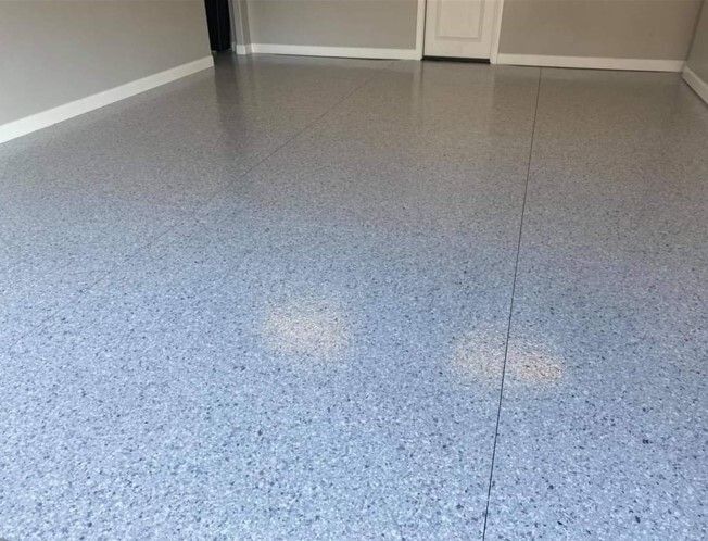 A room with a blue concrete floor and a door.