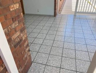 A tiled floor with a brick wall in the background.