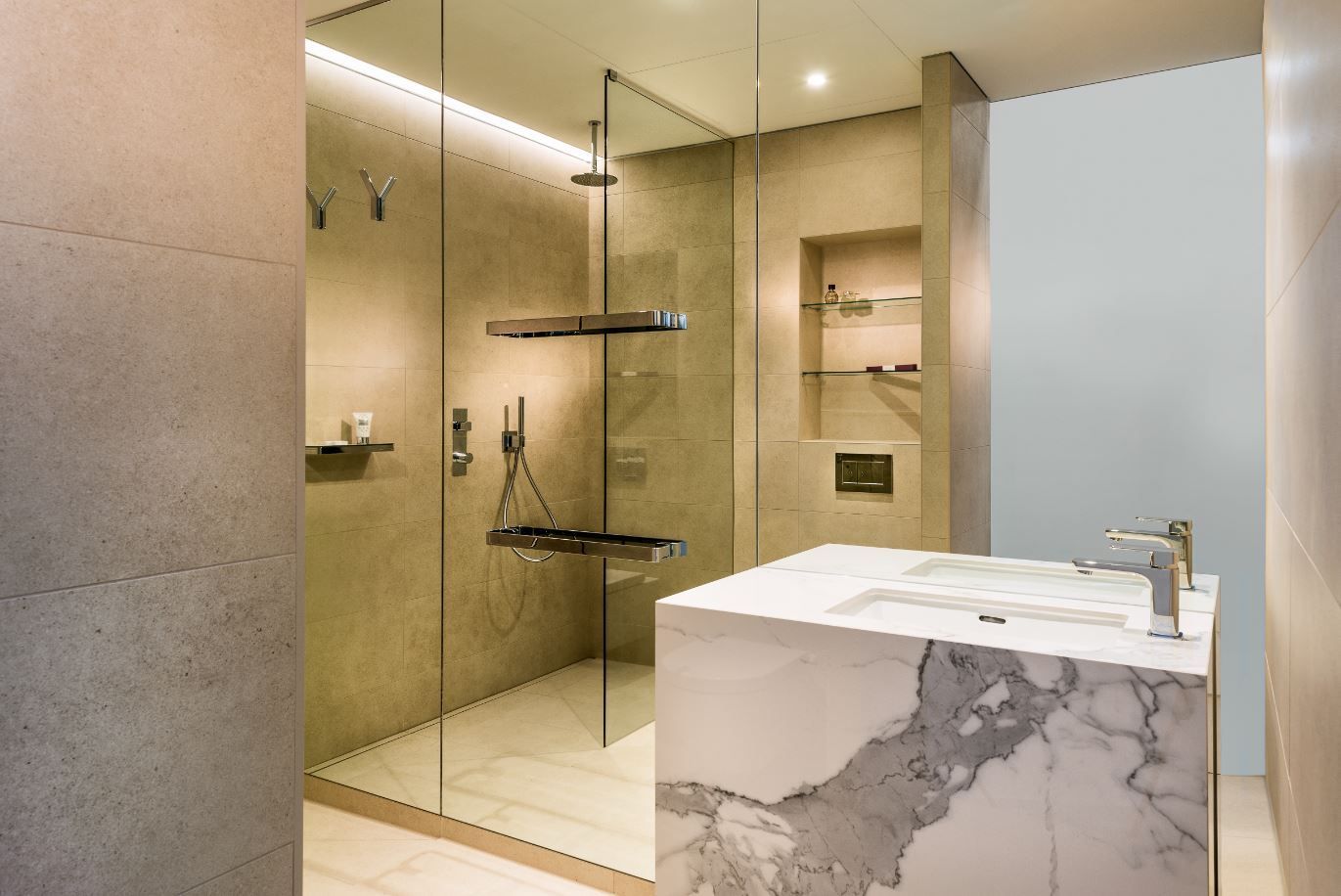 Modern bathroom with marble vanity and glass shower. Beige tones, neutral lighting.