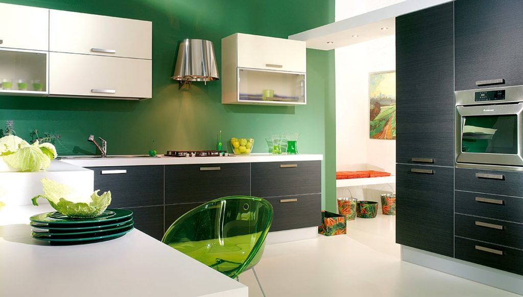 Modern kitchen with green wall, white countertops, black cabinets, and clear green chair.