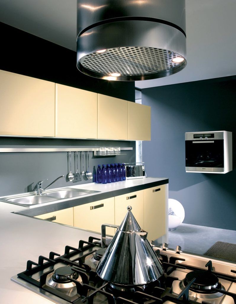Modern kitchen with stove, oven, cabinets, and stainless steel hood.