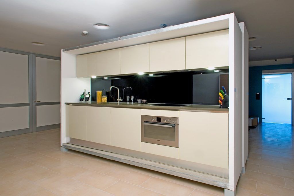 Modern kitchen with light-colored cabinets, stainless steel appliances, and a black backsplash within a white frame.