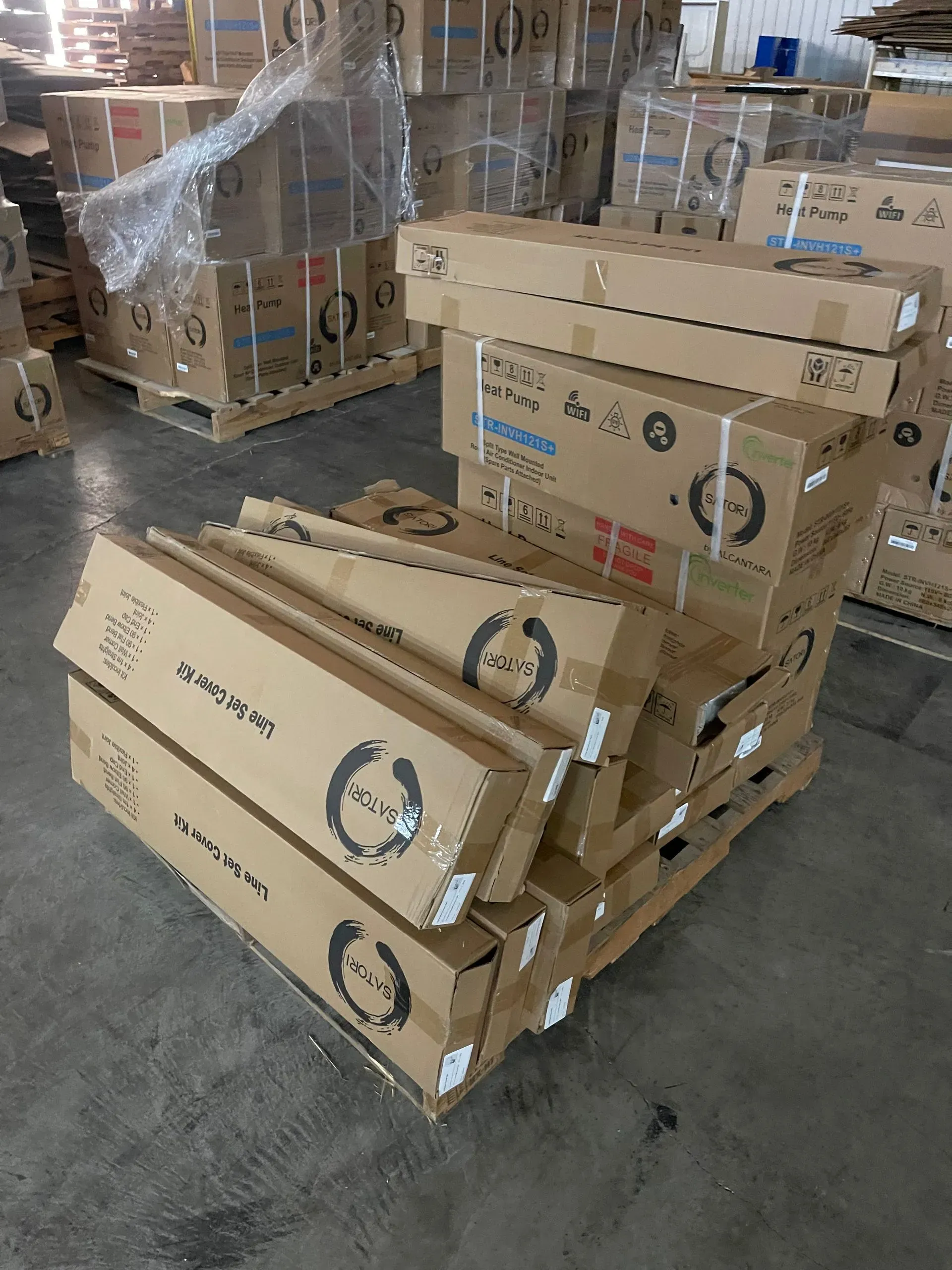 Pallet of stacked cardboard boxes with brand logo in a warehouse.